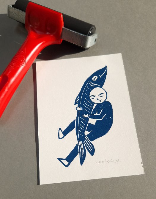 Stilisierte Person einen riesigen Fisch umarmend in Drunkelblau gedruckt auf weißem Papier