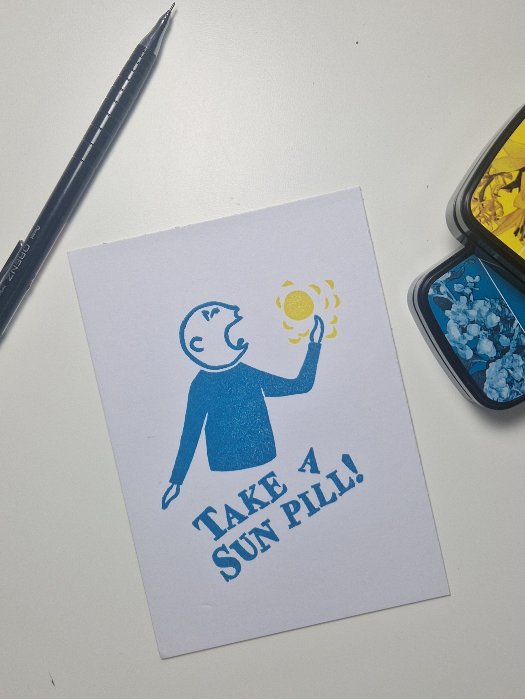 Stilisierte Person in Blau, die sich eine gelbe Sonne in den Rachen wirft mit der Bildunterschrift 'Take a Sun Pill!' gedruckt auf weißem Papier